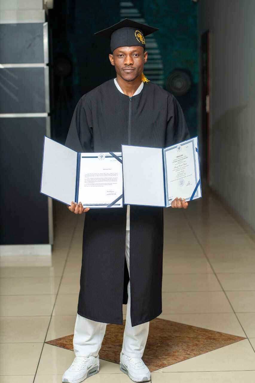 Dyplom i nagroda Pan David trzymający w ręku dyplom ukończenia studiów i nagrodę za najelpsze wyniki w nauce