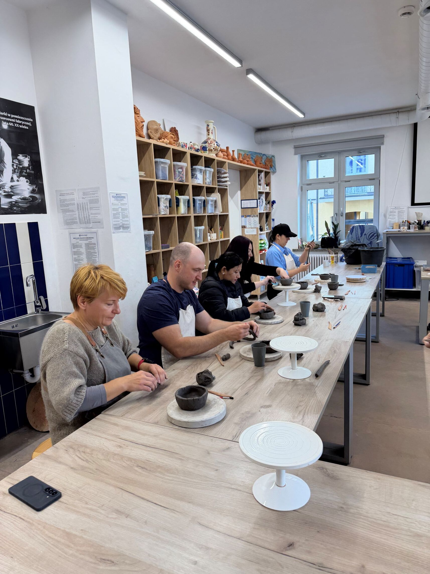 Uczestnicy projektu lepią naczynia w trakcie warsztatów ceramicznych. Cudzoziemcy poznają tradycję włocławskiego fajansu.